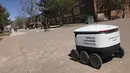 Sebuah robot pengantar makanan melintasi kampus Northern Arizona University di Flagstaff, Arizona, Amerika Serikat, Selasa (26/3). Ada lusinan robot pengantar makanan di kampus ini. (Ben Shanahan/Arizona Daily Sun via AP)