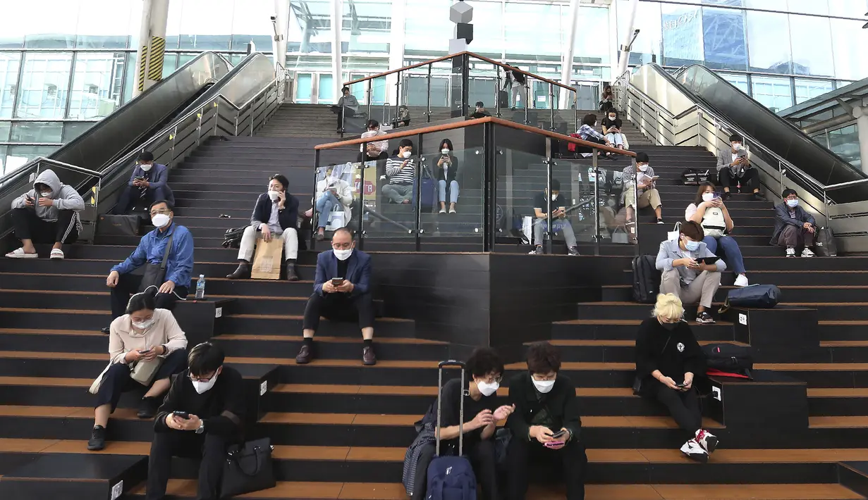 Orang-orang yang memakai masker wajah untuk membantu melindungi dari penyebaran virus corona menunggu kereta mereka menjelang liburan Chuseok atau Hari Thanksgiving versi Korea di Stasiun Kereta Seoul di Seoul, Korea Selatan, Selasa (29/9/2020). (AP Photo / Ahn Young-joon)