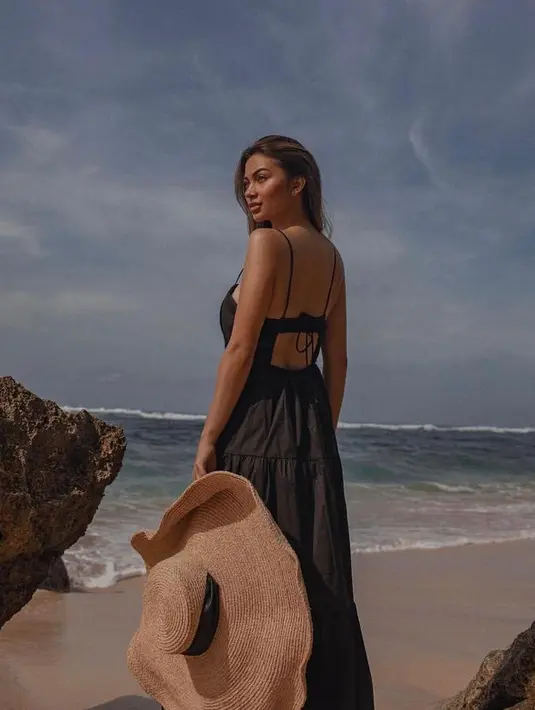 Tampil dramatis, Ariel Tatum terlihat mengenakan ruffle maxi dress warna hitam. Tampilannya itu dilengkapi dengan floppy hat berukuran besar. (Instagram/arieltatum/anaditya_).