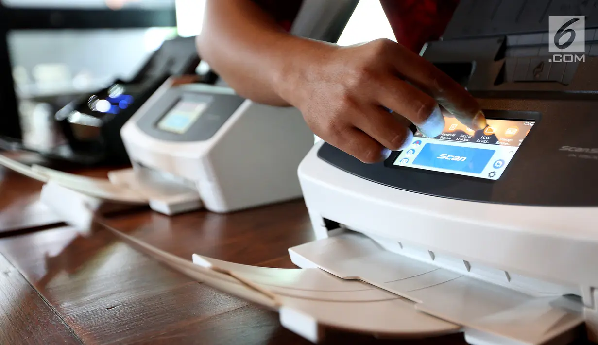 Seorang karyawan mengoperasikan scanner Fujitsu ScanSnap iX1500 di Jakarta, Selasa (19/3). Scanner yang mendukung Making Indonesia 4.0 dengan digitalisasi dokumen dapat membantu bisnis menjadi lebih cepat dan efisien. (Liputan6.com/Fery Pradolo)