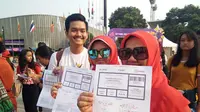 Penonton dari Palembang memperlihatkan tiket untuk menonton closing ceremony Asian Para Games 2018 (Liputan6.com/Cakrayuri Nuralam)