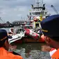 Dua orang petugas Basarnas memperhatikan kondisi bangkai badan pesawat Airasia QZ8501 yang berhasil dievakuasi, Pelabuhan Tanjung Priok, Jakarta, Senin (2/3/2015). (Liputan6.com/Faizal Fanani)