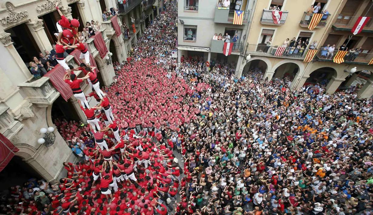 Ratusan penonton berkerumun melihat kompetisi menara manusia di festival Sant Joan, Spanyol, Selasa (24/6/14). (REUTERS/Albert Gea)