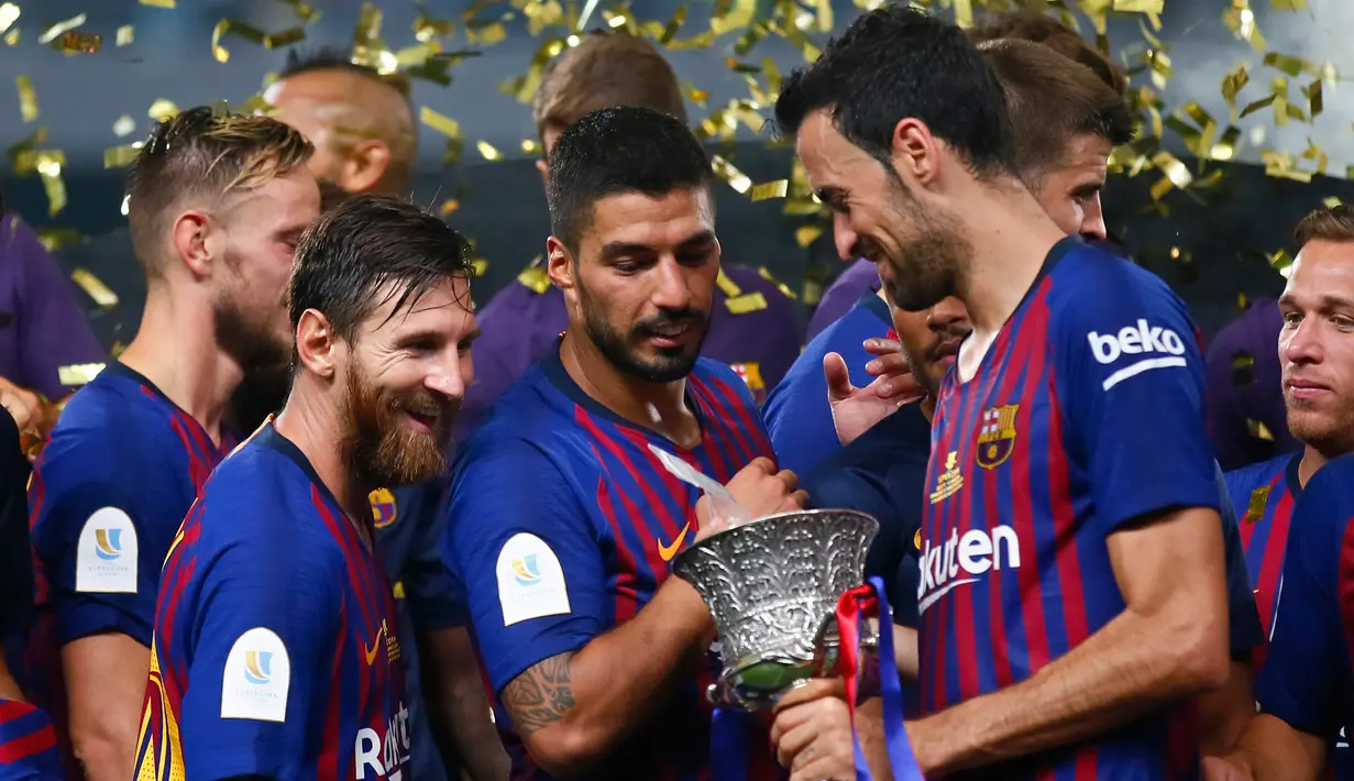 Pemain Barcelona melihat Piala Super Spanyol usai pertandingan melawan Sevilla di Tangier, Maroko, (13/8). Barcelona meraih gelar ke-13 di Piala Super Spanyol terbanyak ketimbang tim lain. (AP Photo/Mosa'ab Elshamy)