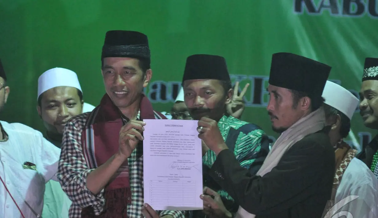 Mendapat todongan tersebut, Jokowi yang berada di panggung langsung menandatanganinya.  Jokowi memperlihatkan surat pernytaan kesediaannya, Malang, Jumat (27/6/2014) (Liputan6.com/Herman Zakharia)