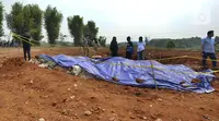 Warga memeriiksa tempat penemuan beras diduga bansos presiden di kawasan Kampung Serab, Sukmajaya, Depok, Jawa Barat, Rabu (3/8/022). Dari pemeriksaan sementara diketahui pihak JNE mengubur beras bansos Covid-19 itu pada 5 November 2021. (merdeka.com/Arie Basuki)