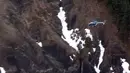 Sebuah helikopter penyelamat terbang di atas puing pesawat A320 Airbus Germanwings yang jatuh antara kota Barcelonnette dan Digne di Pegunungan Alpen Prancis, Selasa (24/3/2015). (AFP PHOTO /DENIS BOIS /GRIPMEDIA / AFP TV)