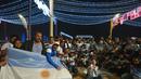 Fans Argentina bersorak di Doha corniche, di Doha, Qatar, Senin, 12 Desember 2022. Argentina akan menghadapi Kroasia dalam pertandingan semifinal Piala Dunia 2022 di Stadion Lusail Iconic Qatar, Rabu (14/12/2022) mulai pukul 02.00 WIB. (AP Photo/Andre Penner)
