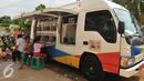 Sejumlah anak membaca buku di mobil perpustakaan keliling di halaman Rusun Cipinang Besar Selatan, Jakarta, Rabu (27/4). Pemprov DKI Jakarta melengkapi fasilitas rusun tersebut berupa perpustakaan dan taman bermain anak. (Liputan6.com/Gempur M Surya)