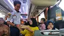 Petugas Badan Pengelola Transportasi Jabodetabek (BTPJ) saat memberikan takjil berbuka puasa bagi para penumpang yang mudik lebih awal di Terminal Poris Plawad, Kota Tangerang, Rabu (12/4/2023). (Liputan6.com/Angga Yuniar)