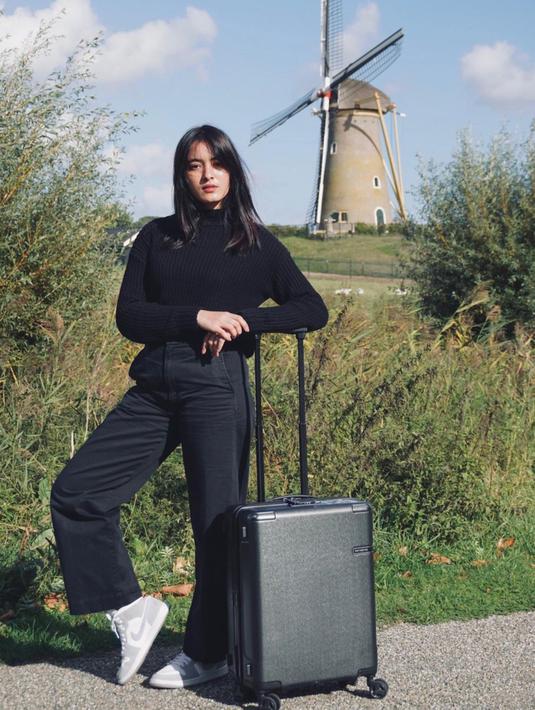 Mawar Eva tampil membawa kopernya dengan background foto bangunan kincir angin dan tak lupa tanaman hijau sebagai pemanis. Pemain film Bumi Manusia ini membagikan momennya saat traveling ke Netherlands, Belanda. (Instagram/@mawar_eva)