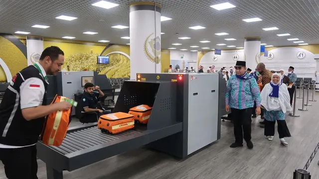 Petugas membantu jemaah haji Indonesia di alat x-ray. Liputan6.com/Nurmayanti