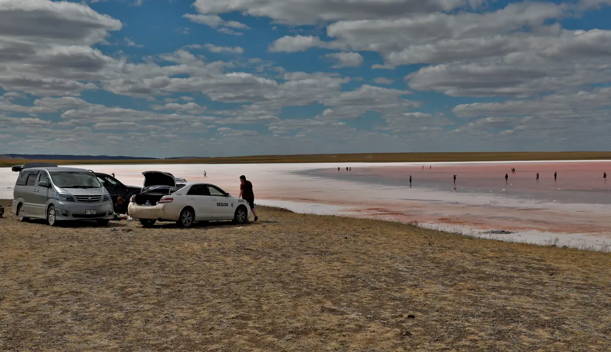 Wisatawan beristirahat di dekat Danau Kobeituz di Kawasan Akmola, Kazakhstan utara (20/6/2020). Danau Kobeituz terkenal dengan warna merah mudanya dan populer di kalangan wisatawan lokal. (Xinhua/Kalizhan Ospanov)