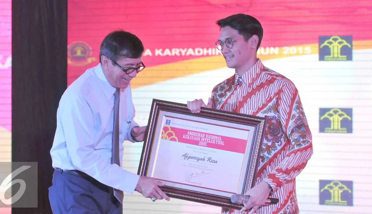 Kemenkumham Yasonna Laoly memberikan penghargaan kepada Afgan sebagai duta HKI Nasional dalam peringatan hari kekayaan intelektual nasional tahun 2015, di Kantor Kemenkumham, Jakarta, Jum'at (30/10/2015). (Liputan6.com/Andrian M Tunay)