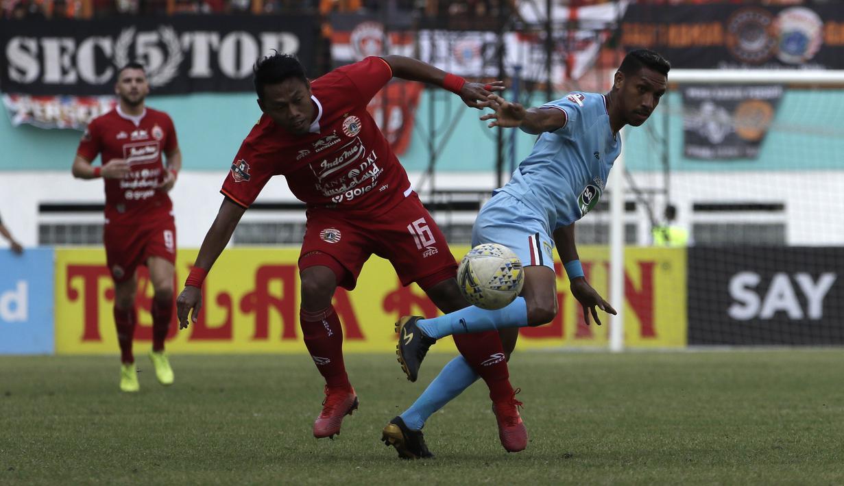 Bek Persija Jakarta, Tony Sucipto, berebut bola dengan striker Persela Lamongan, Delfin Rumbino, pada laga Shopee Liga 1 di Stadion Wibawa Mukti, Bekasi, Jumat (15/11). Persija menang 4-3 atas Persela. (Bola.com/Yoppy Renato)
