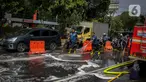 Sejumlah personil pemadam kebakaran membersihkan tumpah oli yang terjadi di Jalan Veteran depan Gedung Krida Bakti, Jakarta, Kamis (16/1/2020). Petugas damkar  melakukan pembersihan dengan cairan deterjen maupun campuran khusus agar jalan tersebut tidak lagi licin. (Liputan6.com/Faizal Fanani)