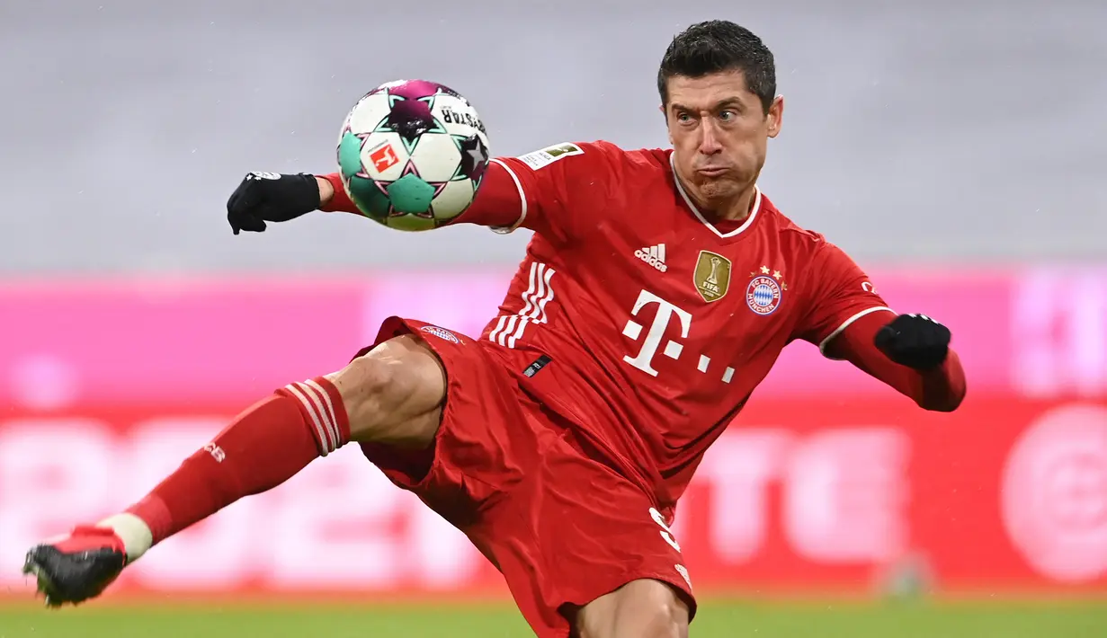 Striker Bayern Munich, Robert Lewandowski melepaskan tendangan yang berbuah gol pertama timnya ke gawang Arminia Bielefeld dalam laga lanjutan Liga Jerman 2020/21 pekan ke-21 di Allianz Arena, Munich, Senin (15/2/2021). Bayern bermain imbang 3-3 dengan Bielefeld. (AFP/Christof Stache/Pool)