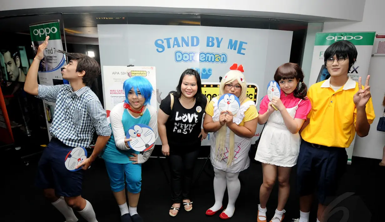 Salah satu peserta Cinemaholic bergaya bersama beberapa orang yang menyerupai tokoh film Doraemon di Blitz Megaplex, Grand Indonesia, Jakarta (13/12/2014). (Liputan6.com/Helmi Fithriansyah)