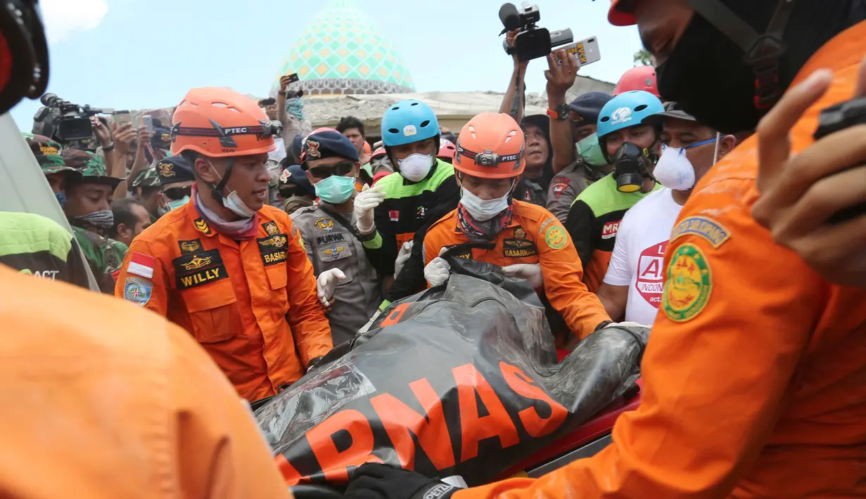 Tim SAR mengevakuasi jenazah korban gempa dari reruntuhan Masjid Jamiul Jamaah di Bangsal, Lombok Utara, Rabu (8/8). Bagian utara Lombok hancur oleh gempa pada Minggu malam dan merusak ribuan bangunan serta menewaskan banyak orang. (AP/Tatan Syuflana)