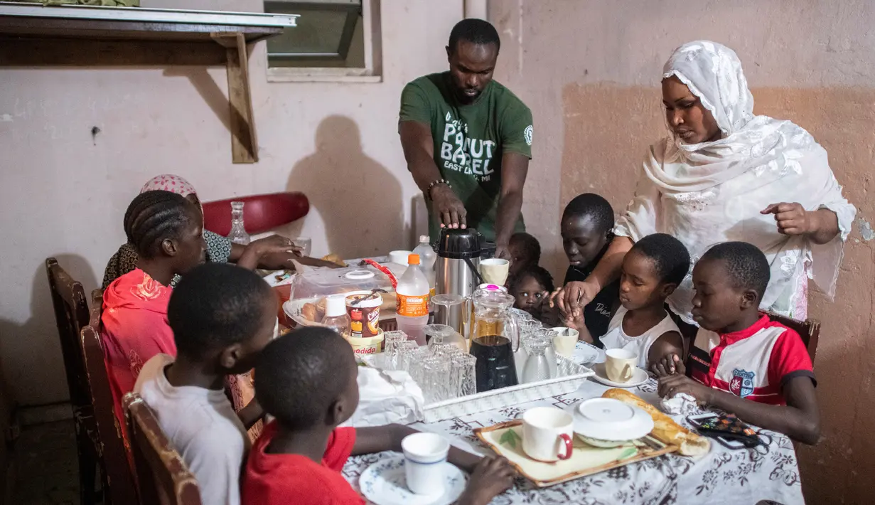 Bara Tambedou (tengah) dan istrinya Mame Sey berbuka puasa bersama keluarga mereka pada hari pertama bulan suci Ramadan, di Dakar, Senegal, Sabtu, (25/4/2020). (AP Photo/Sylvain Cherkaoui)