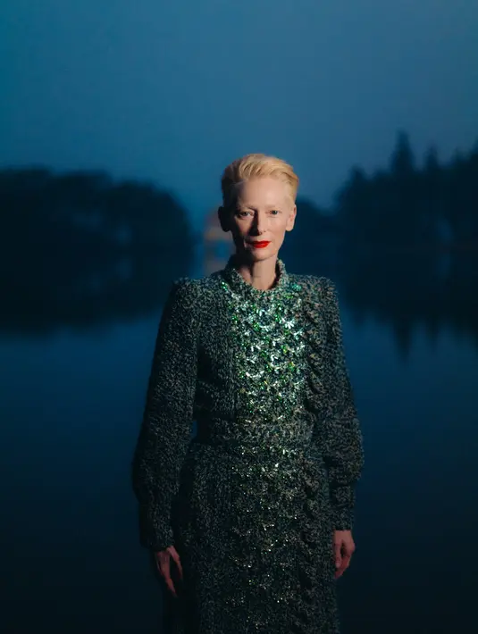 Salah satu yang mencuri perhatian adalah aktris Tilda Swinton, yang hadir sebagai duta Chanel. Tilda mengenakan tweed midi dress berwarna abu-abu yang memberi kesan anggun dan timeless. Dengan siluet yang minimalis dan warna yang elegan, Tilda Swinton berhasil memancarkan keanggunan yang menjadi ciri khasnya. [Dok/Chanel].