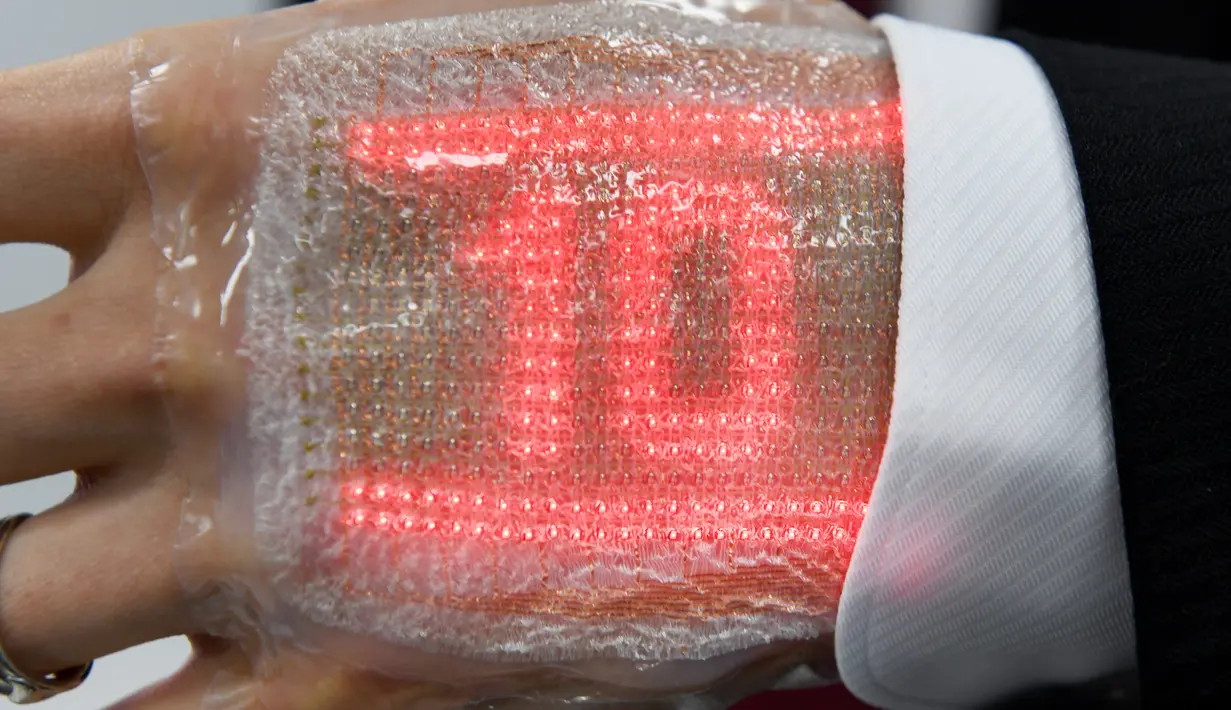 Layar elastis ultra tipis bergambar angka sepuluh saat dipamerkan di Tokyo, Jepang (14/2). Alat ini dapat menerima pesan, termasuk emoji dan dapat memantau kesehatan penggunanya. (AFP Photo/Toru Yamanaka)