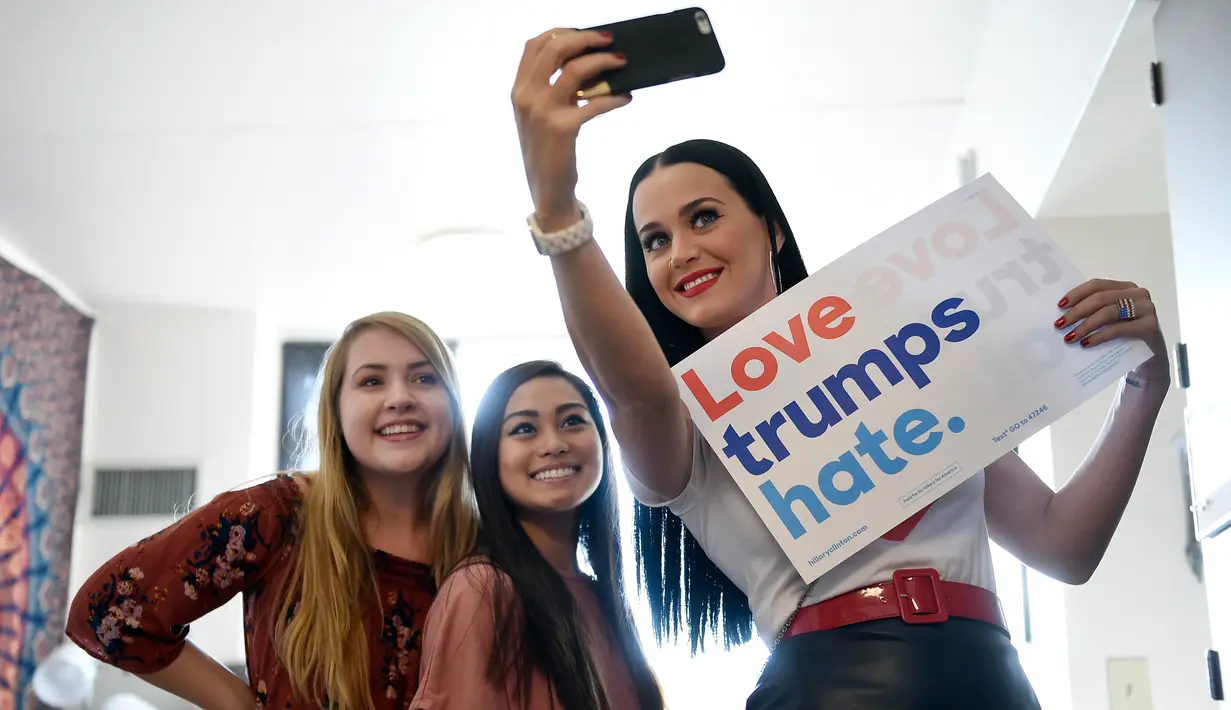 Penyanyi Katy Perry berfoto bersama sejumlah penghuni kamar asrama di Universitas Nevada, Las Vegas, dalam usahanya menggalang dukungan untuk capres AS Hillary Clinton, Sabtu (22/10). (David Becker/Getty Images/AFP)