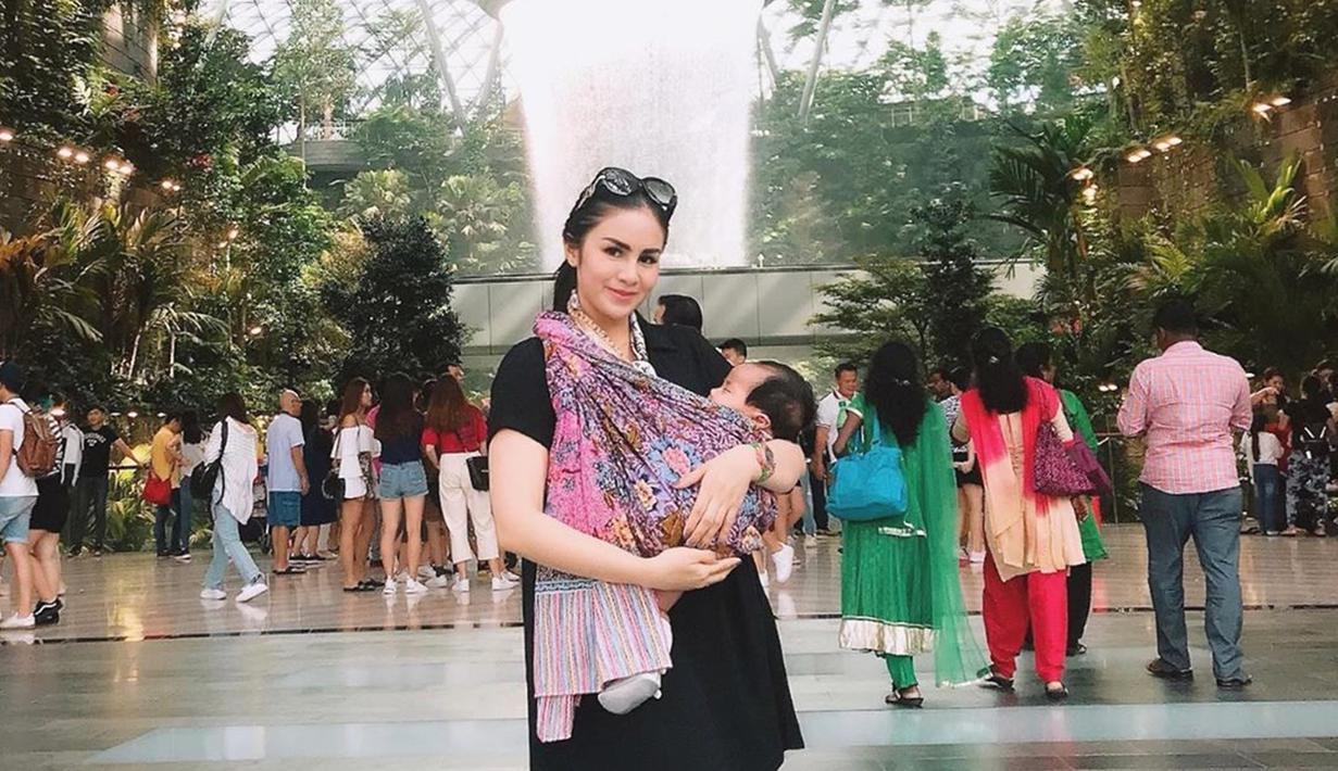 Kehadiran anak pertamanya ini menjadi momen paling membagiakan bagi Momo Geisha, salah satu momen unik terjadi saat Momo menggendong si buah hatinya dengan kain jarik saat berada di Bandara Singapore. (Liputan6.com/IG/@therealmomogeisha)