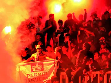 Suporter menyalakan suar saat merayakan kemenangan Persib atas Semen Padang di perebutan tempat ketiga Piala Presiden 2017 di Stadion Pakansari, Kab Bogor, Sabtu (11/3). Persib meraih tempat ketiga usai unggul 1-0. (Liputan6.com/Helmi Fithriansyah) 