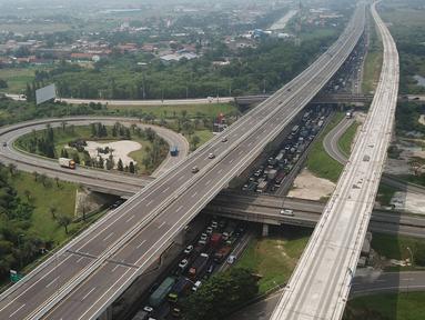 Foto aerial antrean kendaraan yang melintas di Km 34 B Tol Jakarta - Cikampek (Japek), Cikarang, Sabtu (22/5/2021). Polda Metro Jaya memprediksi puncak arus balik mudik Lebaran ke DKI Jakarta akan terjadi pada akhir pekan ini, 21-23 Mei 2021. (Liputan6.com/Herman Zakharia)