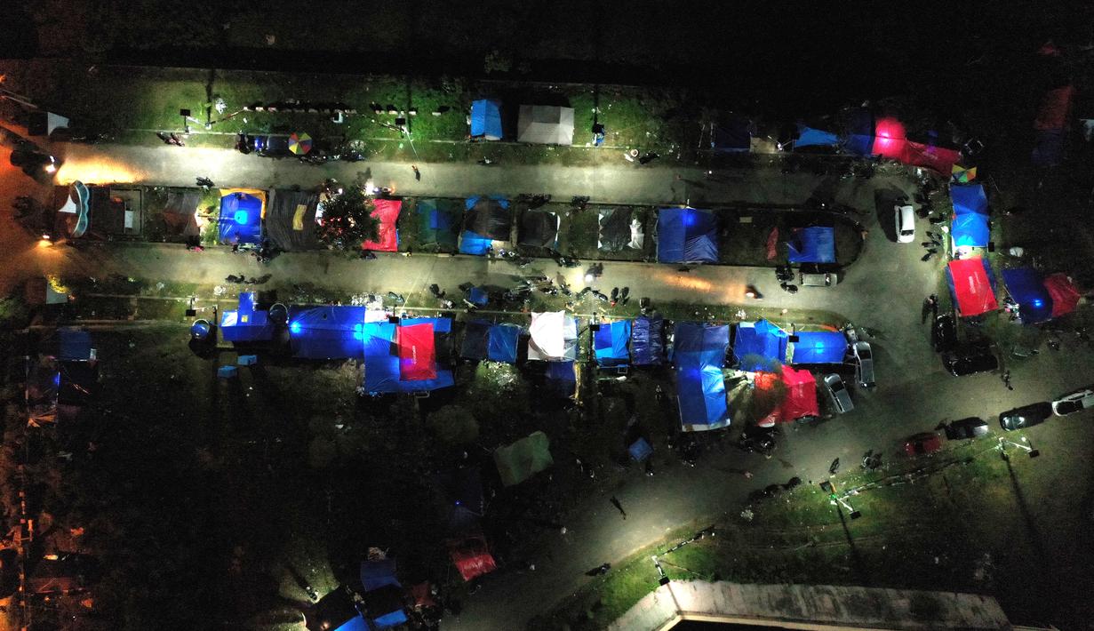 Foto udara menunjukkan tenda-tenda di tempat penampungan darurat di Mamuju (19/1/2021). Basarnas menyebut hingga pukul 16.00 WIB, Senin (18/1/2021) sebanyak 84 orang meninggal akibat gempa yang terjadi di Sulawesi Barat (Sulbar). (AFP/Adek Berry)