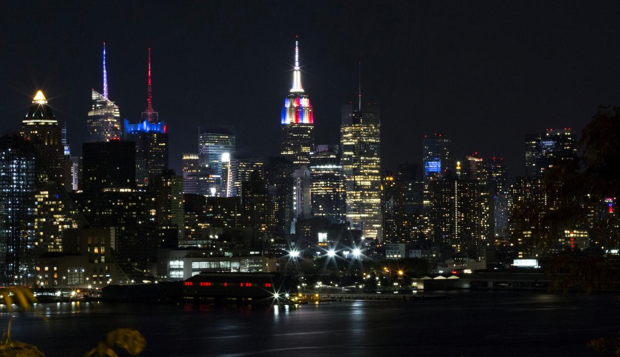Gedung pencakar langit Empire State di New York memancarkan lampu warna bendera juara Piala Dunia 2018, Prancis, Minggu (15/7). Sebelumnya, pucak gedung terkenal di Amerika Serikat itu selalu menyalakan warna putih. (AFP PHOTO / KENA BETANCUR)