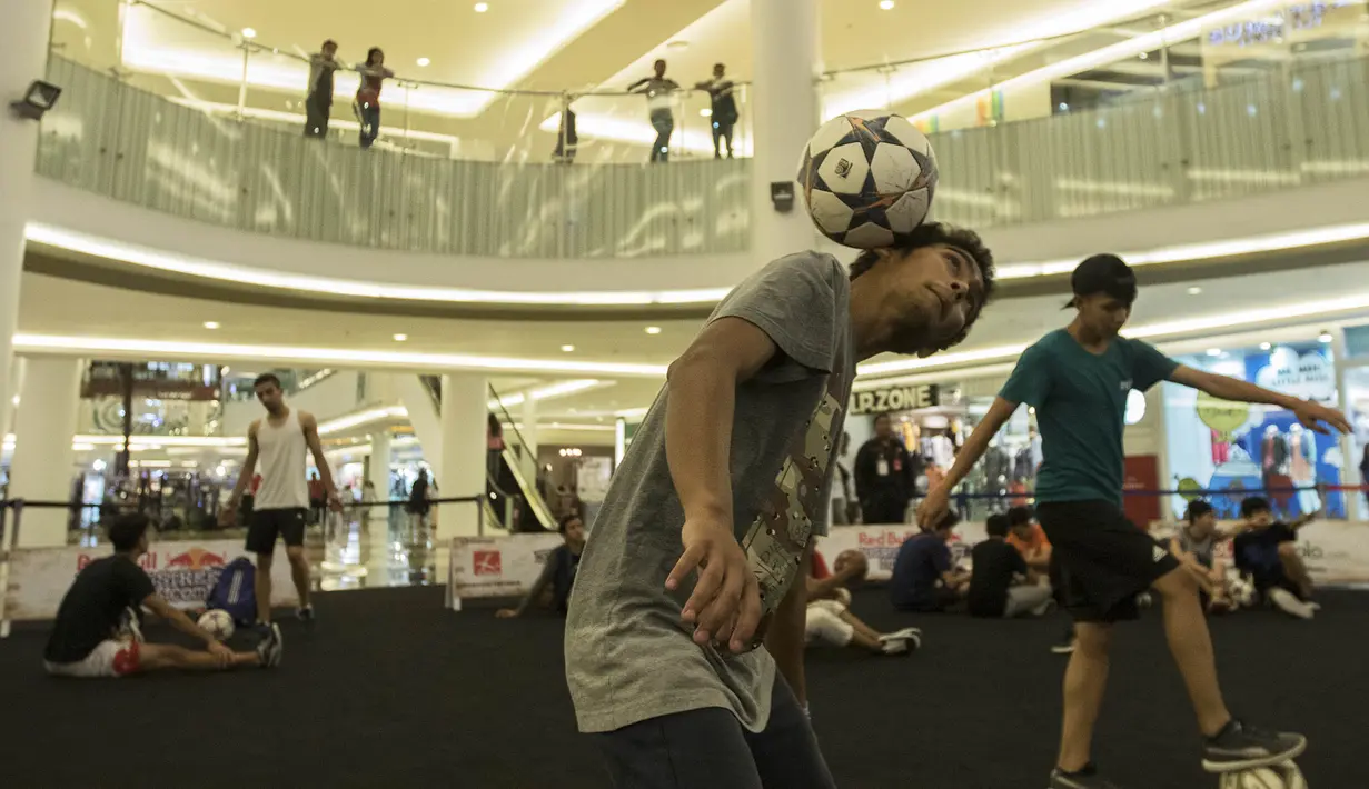 Seorang freestyler mengontrol bola dengan kepala saat pemanasan jelang penampilannya pada turnamen Indonesian Freestyle Football Championship di Mall Pluit Village, Jakarta, Sabtu (14/11/2015). (Bola.com/Vitalis Yogi Trisna)