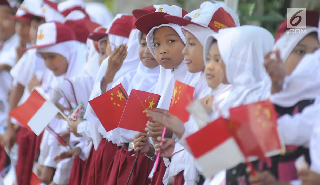 Sejumlah murid menyambut kedatangan PM China Li Keqiang di kawasan Istana Bogor, Senin (7/5). Li juga akan membahas peningkatan hubungan kerja sama perdagangan Indonesia-China. (Merdeka.com/Arie Basuki)