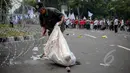 Pemulung memungut sampah saat peringatan hari buruh sedunia yang jatuh pada tanggal 1 Mei di depan Istana Merdeka, Jakarta, Jumat (1/5/2015). Aksi demo May Day menyisahkan sejumlah sampah berserakan di jalan. (Liputan6.com/Faizal Fanani)