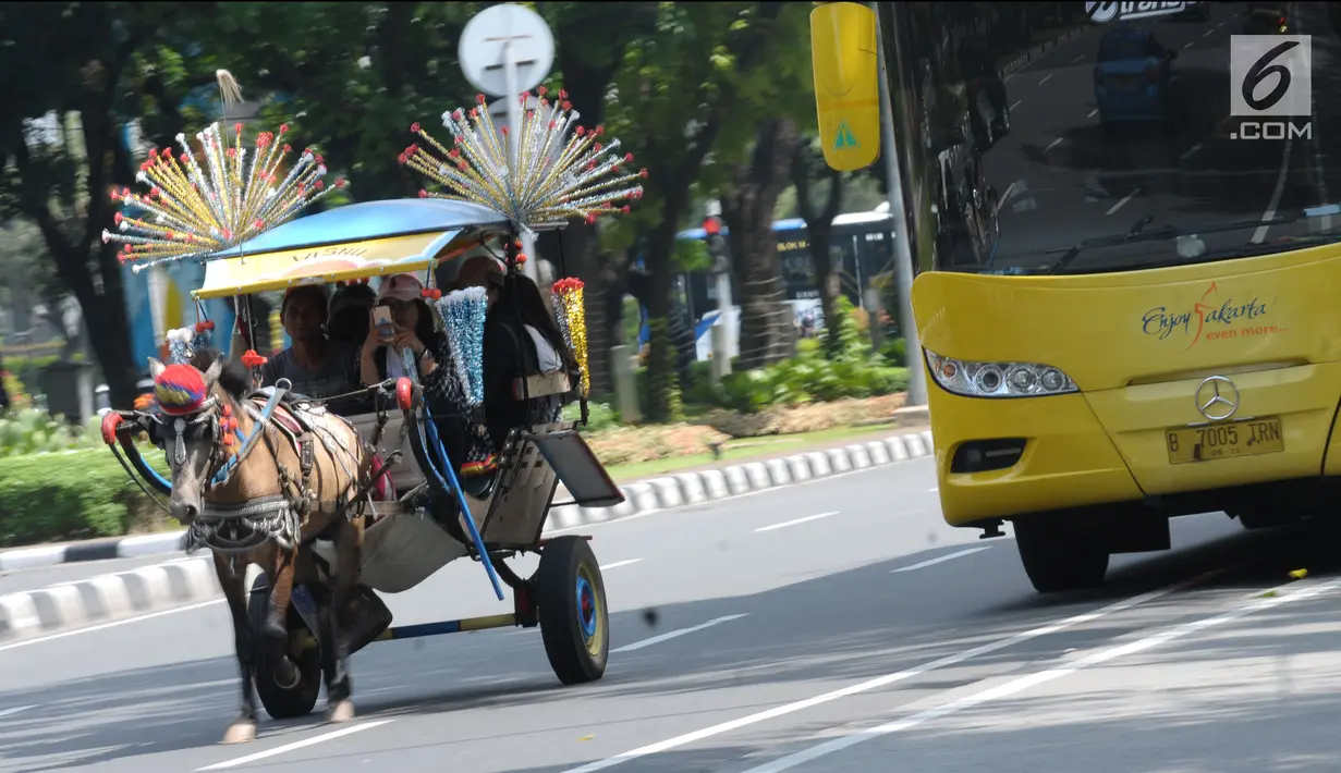 Delman hias membawa penumpang melintasi Jalan Medan Merdeka Selatan, Jakarta, Selasa (19/6). Masa libur Lebaran 2018 dimanfaatkan sejumlah warga untuk berwisata di sekitar Monumen Nasional dengan menaiki delman hias. (Liputan6.com/Helmi Fithriansyah)