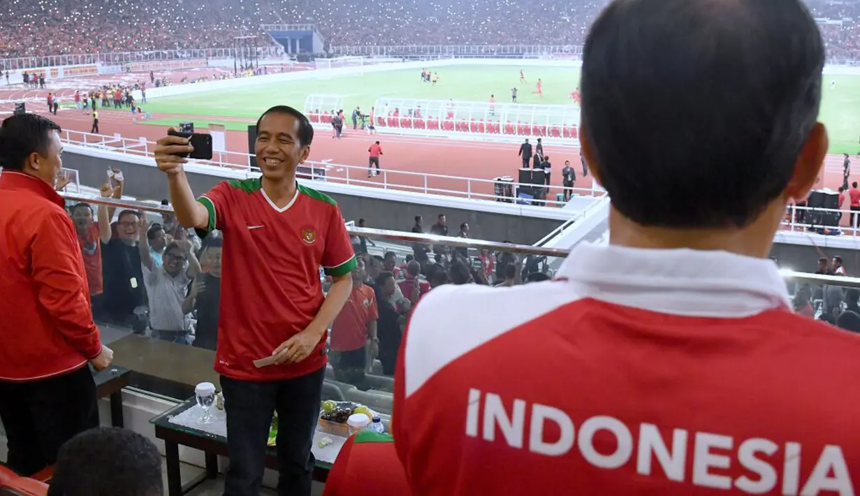 Presiden Jokowi membuat vlog saat laga final Piala Presiden 2018 antara Persija Jakarta vs Bali United di Stadion Utama GBK, Sabtu (17/2). Jokowi juga mengajak Menpora Imam Nahrawi (kiri) ikut terlibat dalam videonya. (Liputan6.com/Pool/Biro Pers Setpres)