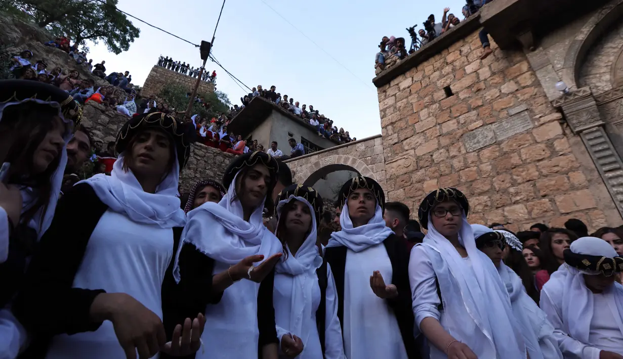 Sejumlah wanita Yazidi Irak mengenakan pakaian tradisional berkumpul di luar kuil Lalish untuk merayakan Tahun Baru Yazidi di lembah dekat Dohuk, Irak (17/4). (AFP/Safin Hamed)