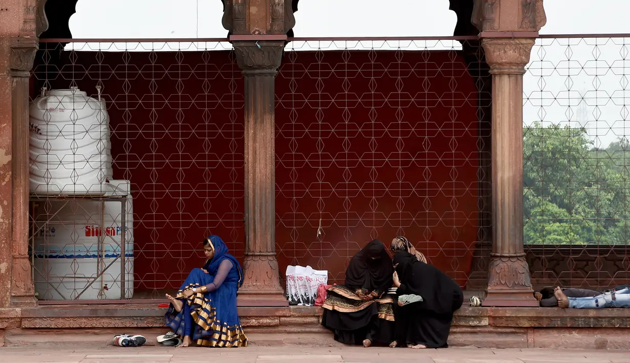 Sejumlah wanita Muslim duduk di masjid Jama  di kawasan lama New Delhi, India (30/7/2019). Masjid ini selesai pada tahun 1656 M dan merupakan yang terbesar dan terkenal di India. (AFP Photo/Money Sharma)