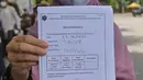 Warga menujukkan hasil Rapid Test Antigen di Rest Area KM 57, Tol Jakarta-Cikampek, Karawang, Jawa Barat, Kamis (24/12/2020). Rapid test antigen tersebut dilakukan untuk meminimalisir lonjakan kasus positif Covid-19 disaat libur Natal dan Tahun Baru 2020. (Liputan6.com/Herman Zakharia)