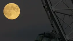 Bulan purnama terakhir tahun ini yang dikenal sebagai Bulan Dingin terbit di sebelah kapsul bianglala London Eye di London, Rabu (7/12/2022). Bulan purnama Desember juga akan berada di atas cakrawala lebih lama dari kebanyakan Bulan purnama, karena lintasannya yang lebih tinggi di langit. (AP Photo/Alastair Grant)