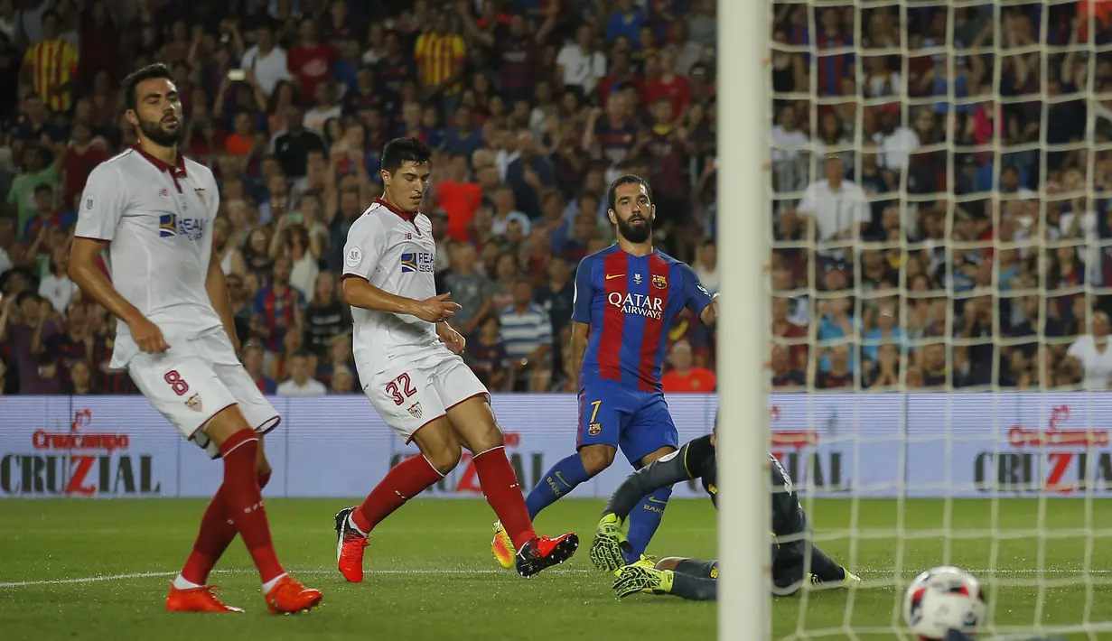 Pemain Barcelona, Arda Turan (kanan) saat mencetak gol ke gawang Sevilla pada laga Super Cup Spanyol di Stadion Camp Nou, Barcelona (18/8/2016). (AP/Manu Fernandez)