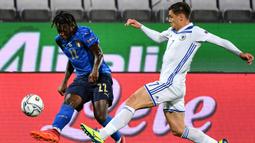 Penyerang Italia, Moise Kean, berebut bola dengan gelandang Bosnia, Muhamed Besic, pada laga UEFA Nations League di  Artemio Franchi, Sabtu (5/9/2020) dini hari WIB. Italia bermain imbang 1-1 atas Bosnia. (AFP/Isabella Bonotto)
