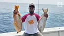 Pemancing menunjukkan ikan hasil tangkapannya pada kegiatan BNI Fun Fishing 2021 di perairan Selat Sunda, Banten, Sabtu (16/10/2021). Para pemancing berlomba-lomba mencari ikan terbesar dan terbanyak yang bisa dibawa pulang. (Liputan6.com/HO/Fun Fishing)