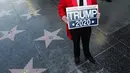 Gregg Donovan berdiri dekat bintang di Walk of Fame Hollywood atas nama Presiden AS Donald Trump yang rusak di Los Angeles, Rabu (25/7). Perusakan Hollywood Walk of Fame Donald Trump itu dilakukan seorang pria dengan menggunakan kapak. (AP/Reed Saxon)
