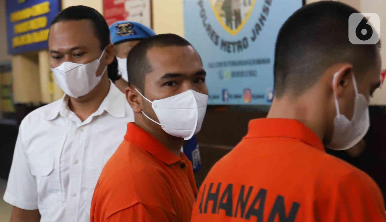 Tersangka pengeroyokan yang juga pengusaha pemilik gerai penjualan gawai, Putra Siregar (tengah) bersama artis Rico Valentino (kanan) dihadirkan saat rilis kasus pengeroyokan di Polres Metro Jakarta Selatan, Rabu (13/4/2022). (Liputan6.com/Herman Zakharia)