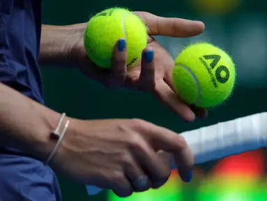 Tangan dengan cat kuku biru milik petenis Denmark, Caroline Wozniacki saat bertanding menghadapi petenis Slovakia Magdalena Rybarikova pada gelaran turnamen tenis Australia Terbuka 2018 di Melbourne, Minggu (21/1).  (AP Photo / Dita Alangkara)