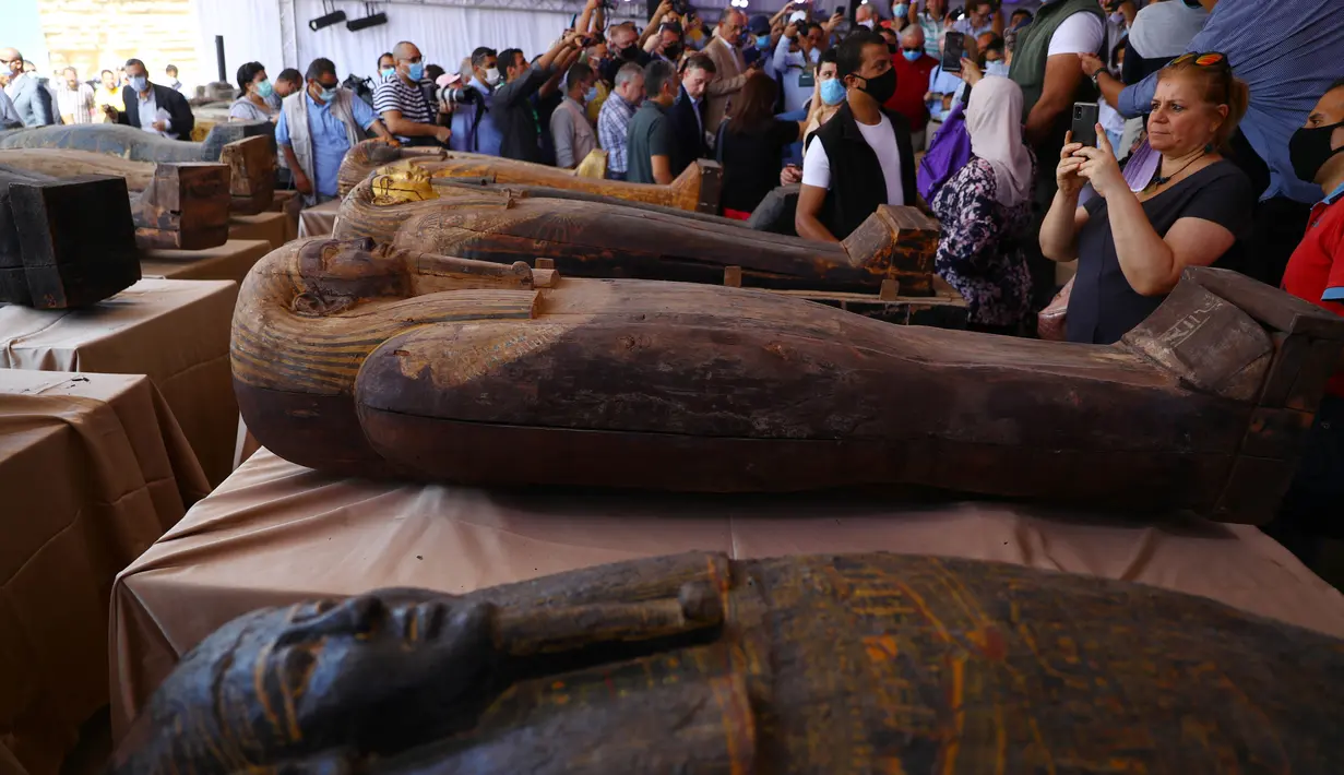 Sejumlah orang mengamati peti mati kuno yang baru ditemukan di situs pemakaman Saqqara di Provinsi Giza, Mesir, 3 Oktober 2020. Kementerian Pariwisata dan Kepurbakalaan Mesir memamerkan 59 peti mati kuno yang baru ditemukan dengan kondisi terawat baik di Provinsi Giza. (Xinhua/Ahmed Gomaa)