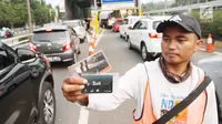 Petugas menjual kartu transaksi tol non tunai di gerbang tol Pejompongan, Jakarta, Jumat (15/9). PT Jasa Marga mulai menerapkan sistem transaksi pembayaran tol non tunai di seluruh Gerbang Tol Cawang-Tomang-Pluit dan Sedyatmo. (Liputan6.com/Angga Yuniar)