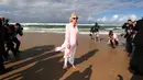 Duchess of Cornwall Camilla berjalan tanpa alas kaki di atas pasir pantai saat mengunjungi Broadbeach di Gold Coast, Kamis (5/4). Pangeran Charles dan Camilia ke Australia untuk menghadiri upacara pembukaan Commonwealth Games. (Mark Metcalfe/POOL/AFP)